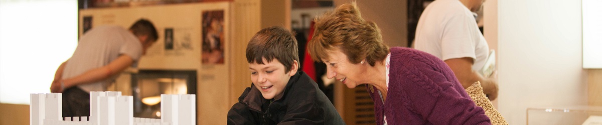 A young boy and an older woman enjoy a castle interactive in the main Civil War gallery